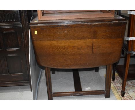 A dark stained Ercol style drawer leaf dining table, approx. width 47cm