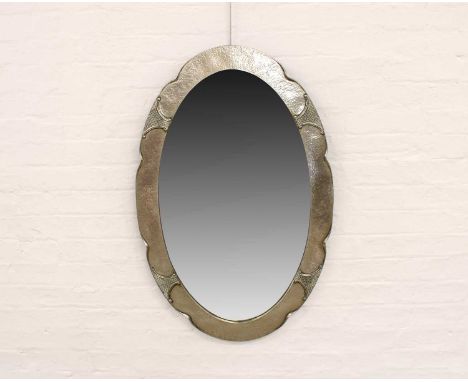 Arts & Crafts Oval Wall Mirror Circa early 20th century, of shaped oval outline, the hammered silver plated frame set with fo