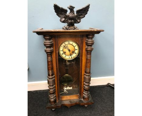 A Victorian wall clock with enamel and glass face, within a cased surround 