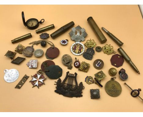 A Lot of military cap badges and badges. Includes Dog tags, Trench art bullet pens/ pencils. Compass &amp; Oil kits. 