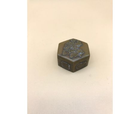A small Japanese snuff/ pill box styled with Lotus flowers and various others. Measures 1.8x3.5cm 