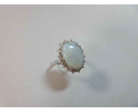 An opal and diamond cluster ring, 18ct white gold the oval cabochon opal claw set in a border of sixteen round brilliant cut 