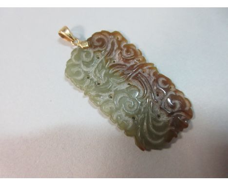 A Chinese jade pendant, the near-rectangular plaque carved with a bird of paradise in swirling foliage, verso carved with clo