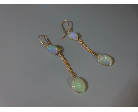 A pair of opal earpendants, each hook suspending two graduated oval cabochon opals, spectacle set and separated by a length o