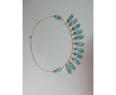 A blue topaz and 18ct gold fringe necklace, fashioned from a barley link chain suspending to the front eleven spectacle set h