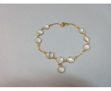 A moonstone and 18ct gold bracelet, with nine round cabochon moonstones spectacle set in line with lengths of chain between e