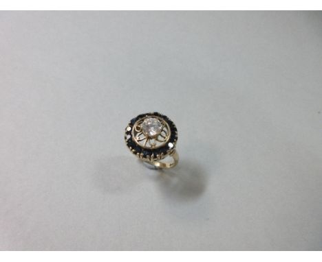 An unusual sapphire and white hardstone target ring cased in an associated Wartski box, the central white stone, possibly a w