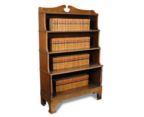 A Regency mahogany waterfall bookcase, with a fret carved gallery back above four open shelves, the lower shelves flanked by 