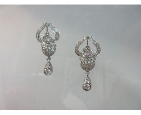 A pair of belle époque style diamond 'lyre and urn' pendant earrings, the articulated and tapered design with a pierced lyre 