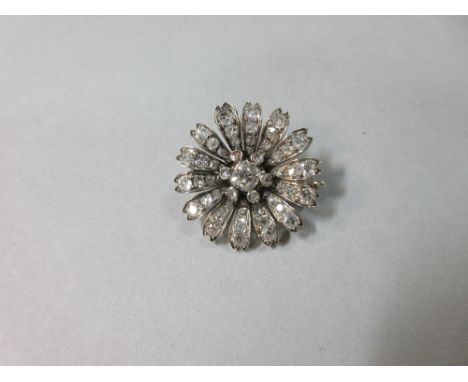 An antique diamond daisy-flower brooch, set to the centre with an old mine cut diamond, estimated weight 0.63cts, with a spac