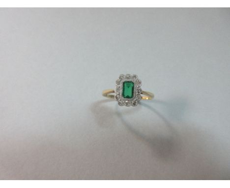 A diamond and green doublet cluster ring, the emerald cut green hardstone doublet in a millegrain scallop-edged border of twe
