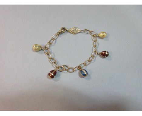 A Fabergé enamel and diamond egg charm bracelet, the loose belcher links suspending five egg charms enamelled variously in re