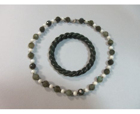 A carved nephrite jade bangle and a dark green labradorite and pearl necklace, the bangle realistically carved as a ropetwist