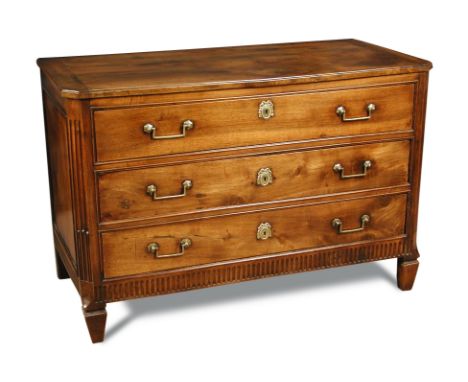 A Louis XVI French chestnut commode, late 18th century with angled fluted corners, three drawers with brass handles and cast 