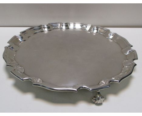 A small silver salver by Harrison Brothers and Howson, Sheffield 1918, circular with shaped and moulded edge raised on three 