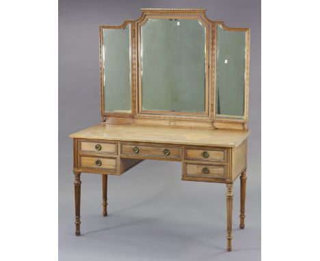 An early 20th century bleached mahogany dressing table with a triple-mirror back, fitted with an arrangement of five drawers,
