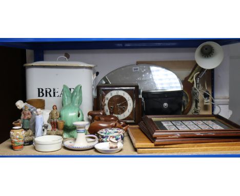 An oval frameless wall mirror, 11¾” x 14¼”; together with an oak cased mantel clock; an enamelled breadbin; &amp; sundry othe
