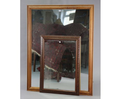 A large pine frame rectangular wall mirror, 52½” x 40½”; &amp; a carved wooden frame rectangular wall mirror inset bevelled p