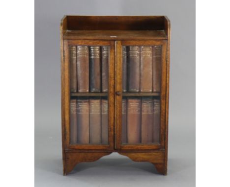 An oak tray-top bookcase fitted centre shelf enclosed by a pair of glazed doors, &amp; on bracket feet, 23¼” wide x 35” high 