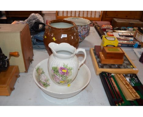 A floral decorated toilet jug and basin; and a glazed earthenware crock etc. 