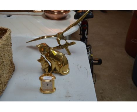 A brass model of an eagle on a branch; a brass cat group; and a carriage style mantel clock 