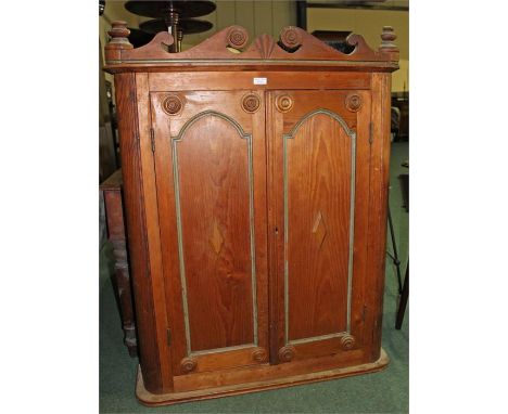 Pine hanging cabinet, the arched top above a pair of panel doors enclosing shelves