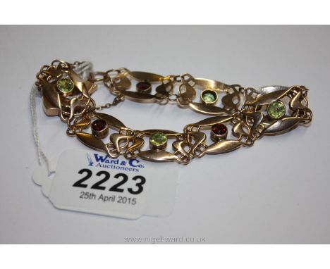 A 9ct Gold art nouveau style openwork Bracelet set with green and red gem stones.