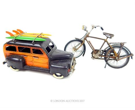 A painted model car with surf boards on the roof, 15 x 29 x 13cm, together with a model bicycle with moveable parts.
