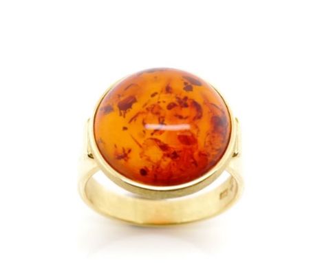 Amber and 18ct yellow gold ring marked k18. Approx weight 5.3 grams, ring size M. Cognac cabochon size 15mm diameter