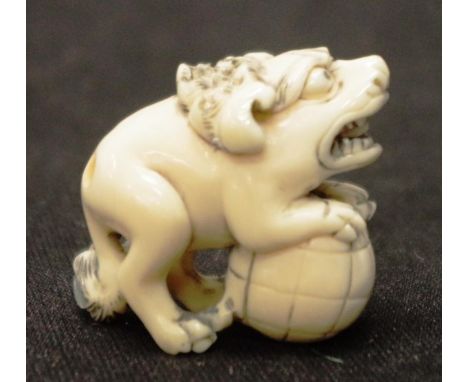 Early carved Ivory Foo dog on ball netsuke C1920, signed to base, height 7.5cm approx. NB.This item cannot be exported.