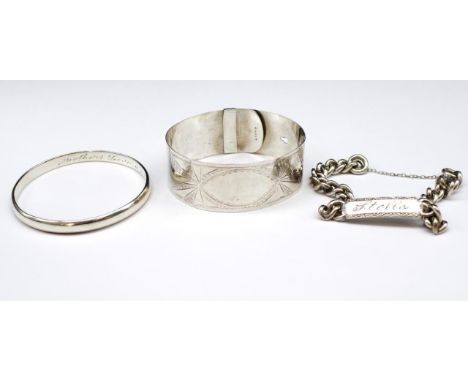 Two silver bangles and a metal ID bracelet includes a buckle type bangle marked sterling and another marked sterling EGK &amp
