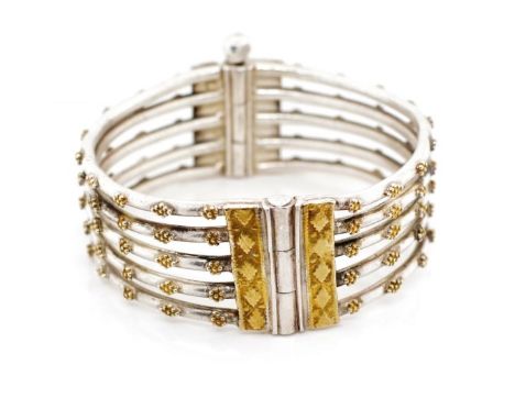 Five bar silver bangle with gilt highlighted bead work and screw pin clasp. Approx inside width 56mm, weight 68 grams. Tests 