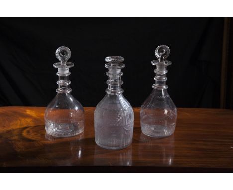 TWO SIMILAR CORK GLASS COMPANY DECANTERS AND MOULDED TARGET STOPPERS, of mallet form with fluted bases and three round neck r