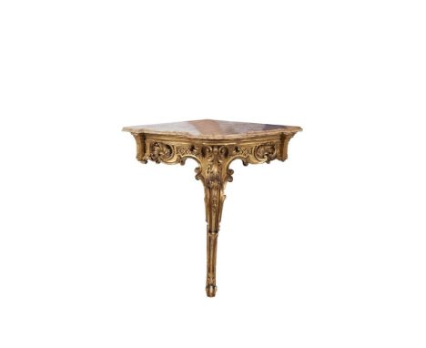A PAIR OF 19TH CENTURY FRENCH GILTWOOD CORNER CONSOLE TABLES, each with a marble top, above moulded frieze, with scroll carto