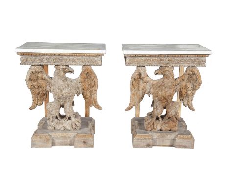 A PAIR OF CARVED LIMED WOOD CONSOLE TABLES, with eagle supports, below a frieze of vitruvian scrolls, and white marble tops, 