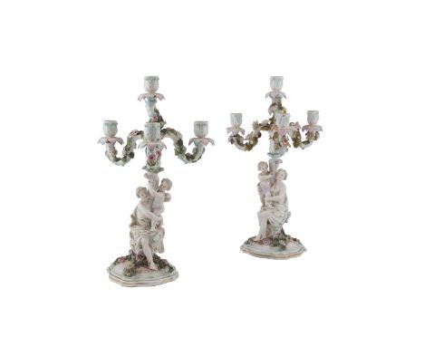 A PAIR OF GERMAN PORCELAIN ROCOCO FOUR-LIGHT CANDELABRA, the stems formed as women holding an infant, painted and encrusted w