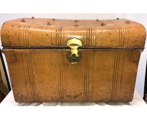 A vintage domed top tin trunk with scrumble glaze decoration, original brass lock and black drop carrying handles. 50 h x 71 