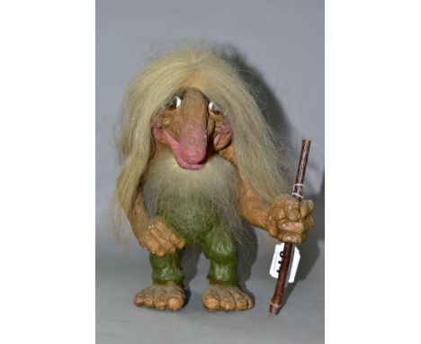 A NORWEGIAN NYFORM TROLL, with hair, beard and furry tail, carrying a stick, height 22cm (Condition report: generally good, s