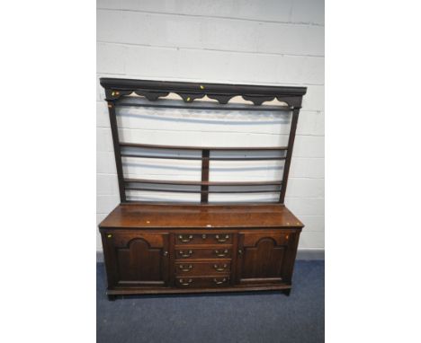 A GEORIAN OAK DRESSER, the two tier plate rack top, over a base with double fielded panel cupboard doors flanking four drawer