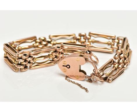 A YELLOW METAL GATE BRACELET, three bar gate bracelet, fitted with a heart clasp and broken safety chain, stamped 9c, length 