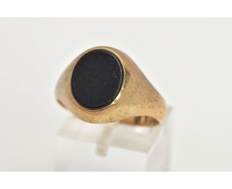 A GENTS 9CT GOLD SIGNET RING, of an oval form set with an onyx panel to a plain polished mount and band, hallmarked 9ct Birmi