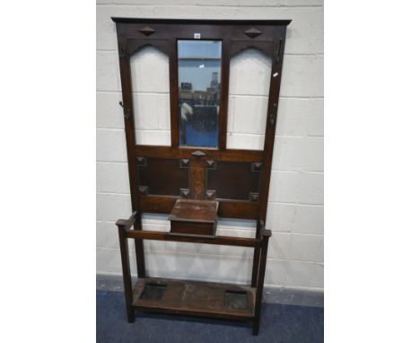 AN EARLY 20TH CENTURY OAK HALL STAND, with four coat hooks (one broken) a single central mirror above two panels and a storag