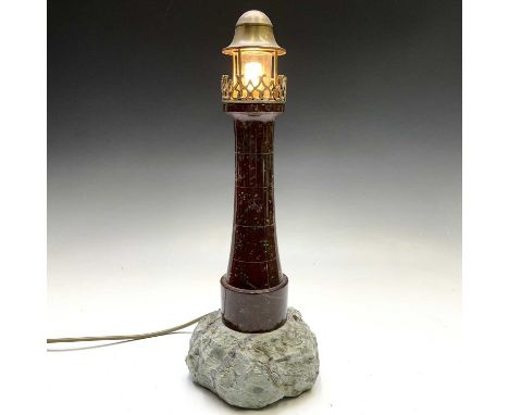 A Cornish serpentine lighthouse lamp, with ornate brass gallery and fitting on a rockwork base, height 43.5cm.No condition is