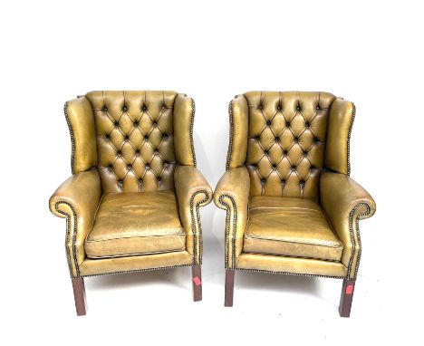 A pair of George III style leather upholstered wing armchairs, height 98cm, width 78cm.All joints are solid and robust, with 