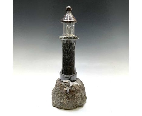 A Cornish serpentine lighthouse table lamp, the rocky base mounted with two painted seagull figures, height 36cm.Chips to top