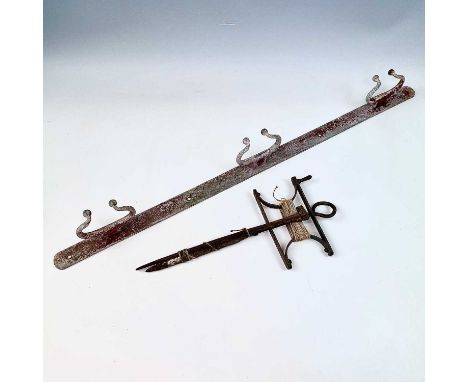 A wrought iron garden string line and winder, height 41cm, together with a cast metal bridle or tool wall rack, width 93cm.