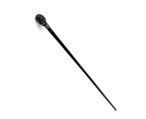 An ebonised walking stick with a carved top in the form of a man's head with enamel eyes, silver collar dated Birmingham 1890