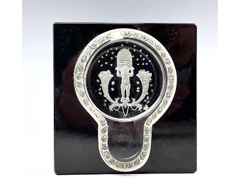 An early 20th century glass cube inkwell, possibly by Baccarat, the clear glass lid intaglio moulded with putti holding aloft