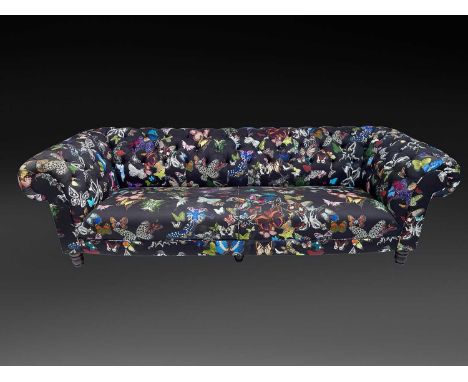 A Chesterfield style three seater sofa covered in Matthew Williamson butterfly print fabric, width 238cm.The fabric is in a g