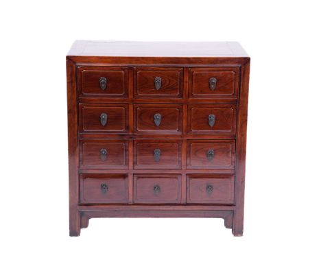 A Chinese cherrywood twelve-drawer chest, probably early 20th century, the plain moulded carcass with flush panelled caddy to